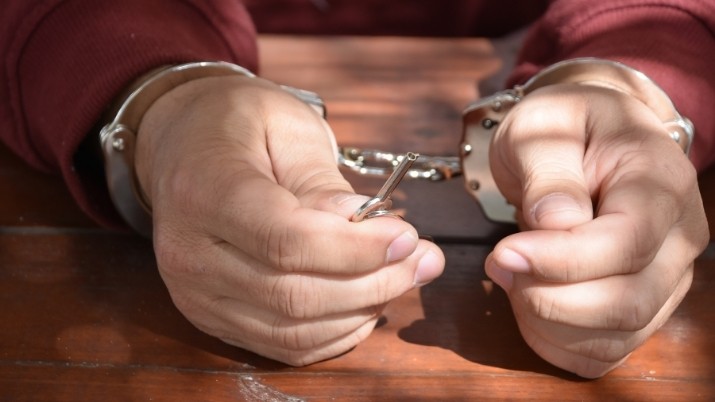 man on hand cuffs after biking while drunk