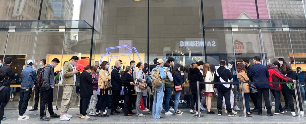 consumers waiting outside a store