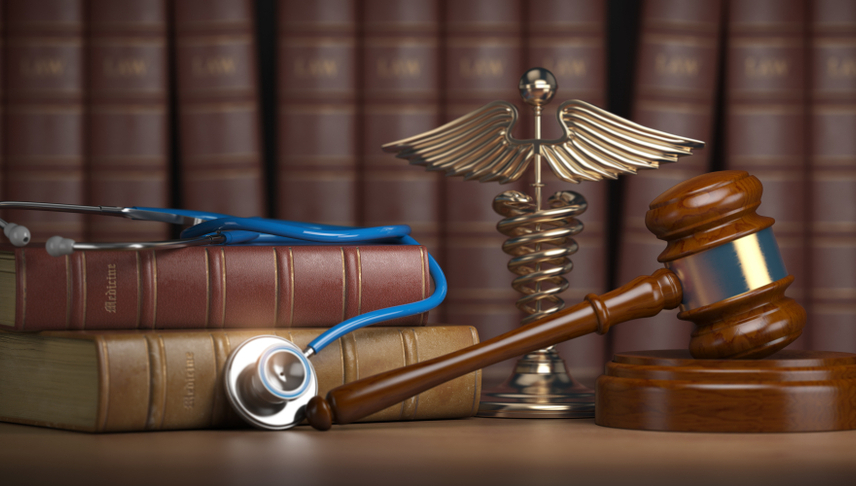 gavel with medical books stethoscope beside of it