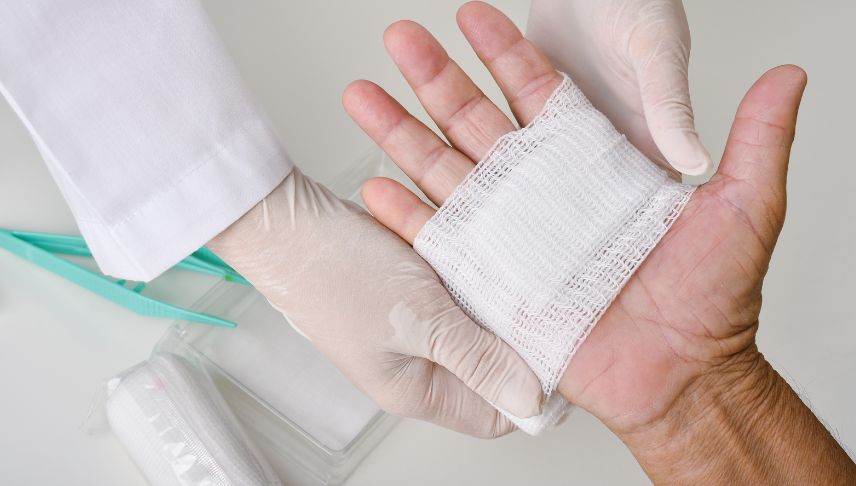 doctor doing wound dressing and bandaging victim hands