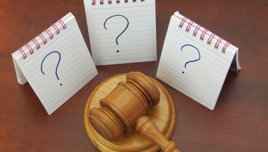 wooden gavel and notepad with question mark