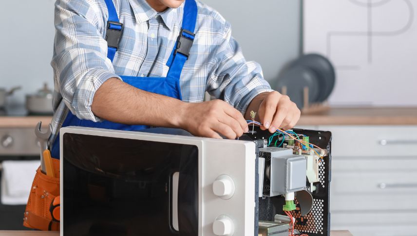 worker checking defective microwave oven